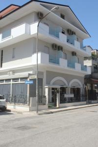 un edificio bianco con un cartello stradale davanti di Hotel Solaris a Giulianova