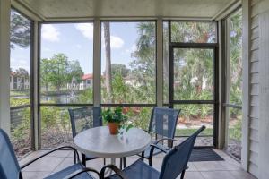 a porch with a white table and chairs and windows at Modern Palm Paradise in Bradenton