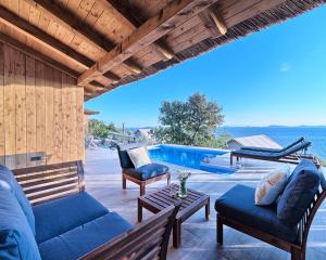 a patio with a couch and chairs and a pool at Golden Haven Luxe Bungalow Resort in Murter