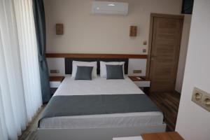 1 dormitorio con 1 cama grande con almohadas azules en AURORA SIĞACIK HOTEL, en Seferihisar