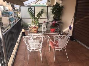 een tafel en stoelen op een balkon met planten bij Enjoy the silence and view in Athene