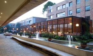 a large building with a fountain in front of it at Hotel Habitel Select in Bogotá