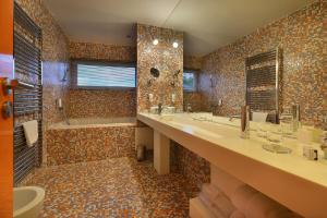 扬斯凯拉兹涅Omnia Hotel Relax & Wellness的配有两个水槽、一个浴缸和一个淋浴的浴室