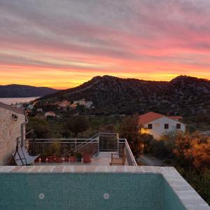 a sunset from a house with a swimming pool at Apartment Igralište Mirakul in Seget Vranjica