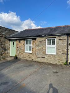a stone house with a green door at Arkleside Country Guest House in Reeth