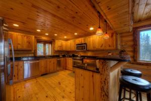 une grande cuisine avec des placards en bois et une cuisinière dans l'établissement Black Diamond Lodge, à Lead