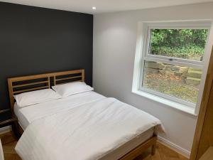 um quarto com uma cama branca e uma janela em Headingley Excellent 1 bedroom apartment em Leeds