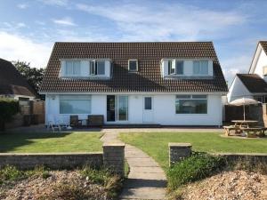 a large white house with a patio and a yard at 11 Shorecroft, Aldwick in Bognor Regis
