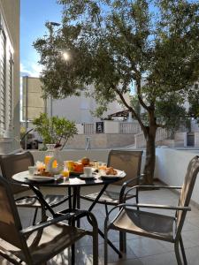 stół i krzesła na patio z drzewem w obiekcie Apartment Oleander w Bol