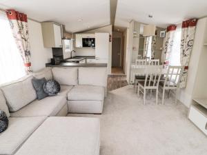 a living room with a couch and a kitchen at Moonlight Lodge in Morpeth +13 photos