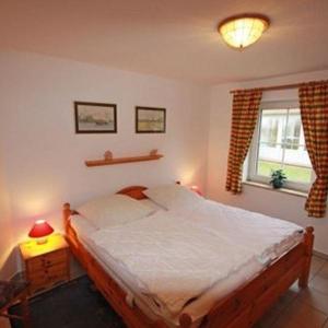 a bedroom with a large bed and a window at Ferienwohnung-Feldblick in Petersdorf auf Fehmarn