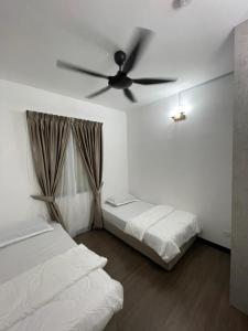 a bedroom with two beds and a ceiling fan at D’Impiana Homestay @Vista Bangi in Kajang