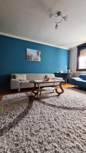 un soggiorno con tavolo e parete blu di Kingston a Pirot