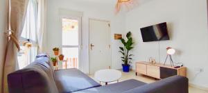 salon z kanapą i telewizorem w obiekcie Agua Marinas - Tu ático con Jacuzzi Privado! w mieście Vera
