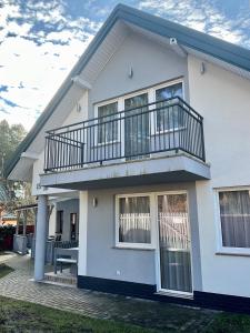 a white house with a balcony on it at Apartamenty u Lucyny i Lecha in Łukęcin
