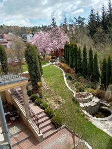 a backyard with a garden with trees and a staircase at Pokoje Gościnne Monti in Kudowa-Zdrój