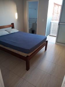 een bed in een slaapkamer met een blauw matras bij Casa praia Itanhaem c piscina in Itanhaém