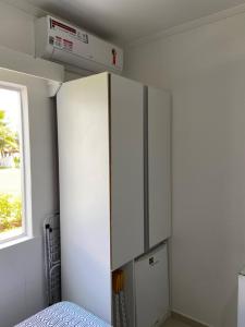 einen weißen Schrank in einem Zimmer mit Fenster in der Unterkunft O paraíso em um flat à beira-mar de Carneiros in Tamandaré