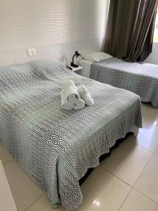 2 Einzelbetten mit Handtüchern darüber in der Unterkunft O paraíso em um flat à beira-mar de Carneiros in Tamandaré