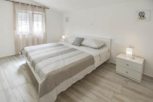 a white bedroom with a large bed and a window at House Roko and Karla in Kali