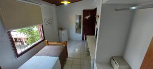 イリャベラにあるRecanto das Carpasのベッドと窓が備わる小さな客室です。