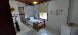Habitación pequeña con mesa y ventana en Recanto das Carpas en Ilhabela