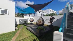 a garden with two umbrellas and some plants at Abiki Mauritius in Albion