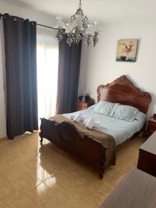 een slaapkamer met een groot bed en een kroonluchter bij Casa Carmelito in Moya