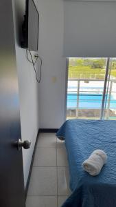 a bedroom with a bed and a view of a pool at Lindos Apartamentos con Piscina in Montenegro
