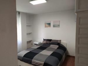 um quarto com uma cama listrada a preto e branco em Céntrico apartamento junto al casco histórico em Córdoba