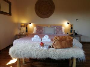 Una cama con dos toallas y una bolsa. en La Masia Costa Brava, en Garrigás