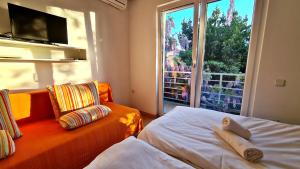 ロバニスカにあるBed & Breakfast Doraのベッド2台、ソファ、窓が備わる客室です。