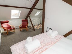a bedroom with a bed and two chairs at The Old Sweet Shop in Alnwick