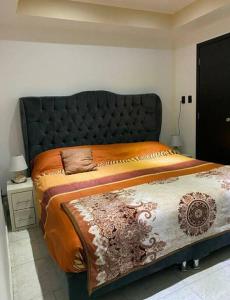 a bed with a black headboard in a bedroom at Depa Frente al aeropuerto 8huespedes 103 in Mexico City
