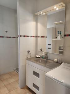 a white bathroom with a sink and a mirror at GITE AUX 4 SAISONS DU COLORADO PROVENÇAL - 3 ÉTOILES - Rustrel in Rustrel