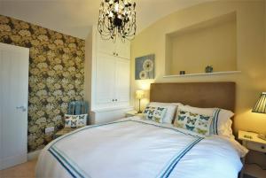 um quarto com uma cama grande e um lustre em The Vault at Westacres em Hexham