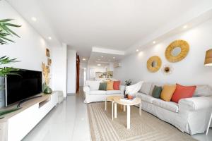 a white living room with a couch and a tv at Villa Maya by Maspalomas Holiday Villas in Pasito Blanco