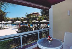 布希奧斯的住宿－Hotel Atlântico Búzios Convention，阳台配有桌子,享有度假胜地的景致。