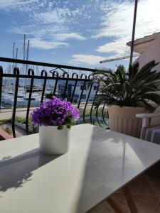 d'un banc blanc avec des fleurs violettes sur un balcon dans l'établissement Apartment Gallery, à Kaštela