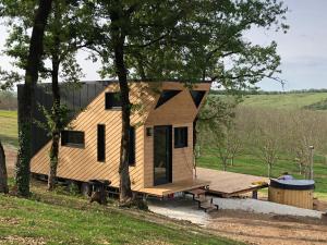 a tiny house on a trailer in a field at Tiny House et bain nordique à la ferme in Cuzance