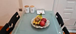 a table with a plate of fruit on it at Gery's Penthouse in Pastida