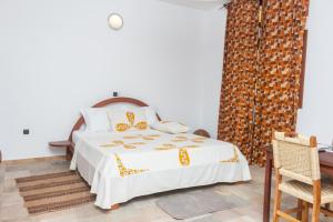 a bedroom with a bed with a white bedspread at Hotel Otsunami in Lomé