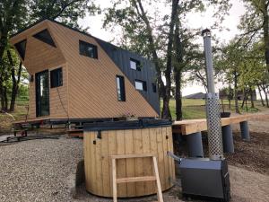 a tiny house sitting on top of a wooden structure at Tiny House et bain nordique à la ferme in Cuzance