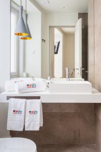 bagno con lavandino bianco e specchio di Bairro Alto Music Guest House a Lisbona