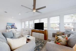 a living room with a couch and a flat screen tv at Mermaid Tales in Dauphin Island