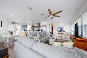 a living room with a large couch and a kitchen at Mermaid Tales in Dauphin Island