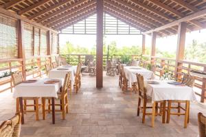 a restaurant with tables and chairs in a room at Hotel Otsunami in Lomé