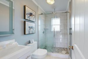 a white bathroom with a shower and a toilet at Mermaid Tales in Dauphin Island +18 photos