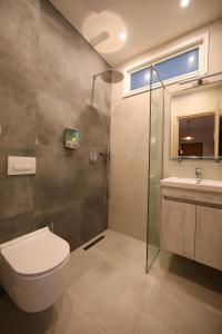 een badkamer met douche, toilet en wastafel bij On the Beach (literally) stylish apartment with free P in Vlorë