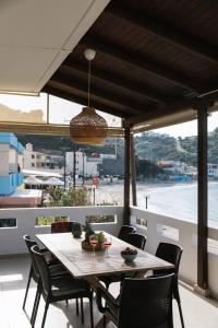 una mesa y sillas en un balcón con vistas al agua en Beach front apartment with swimming pool, en Ligaria